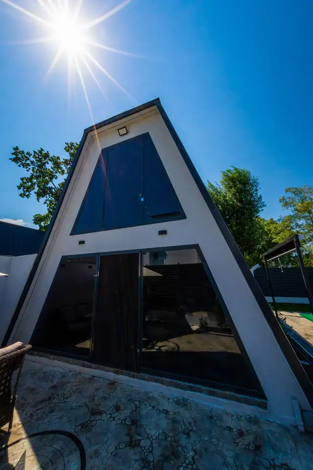 Bungalovun lacivert metal kaplamalı dış cephesi, güneş ışığında